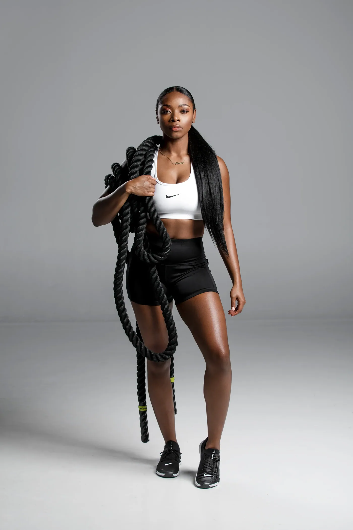 Victoria Tapp, personal trainer, holding a battle rope over one shoulder